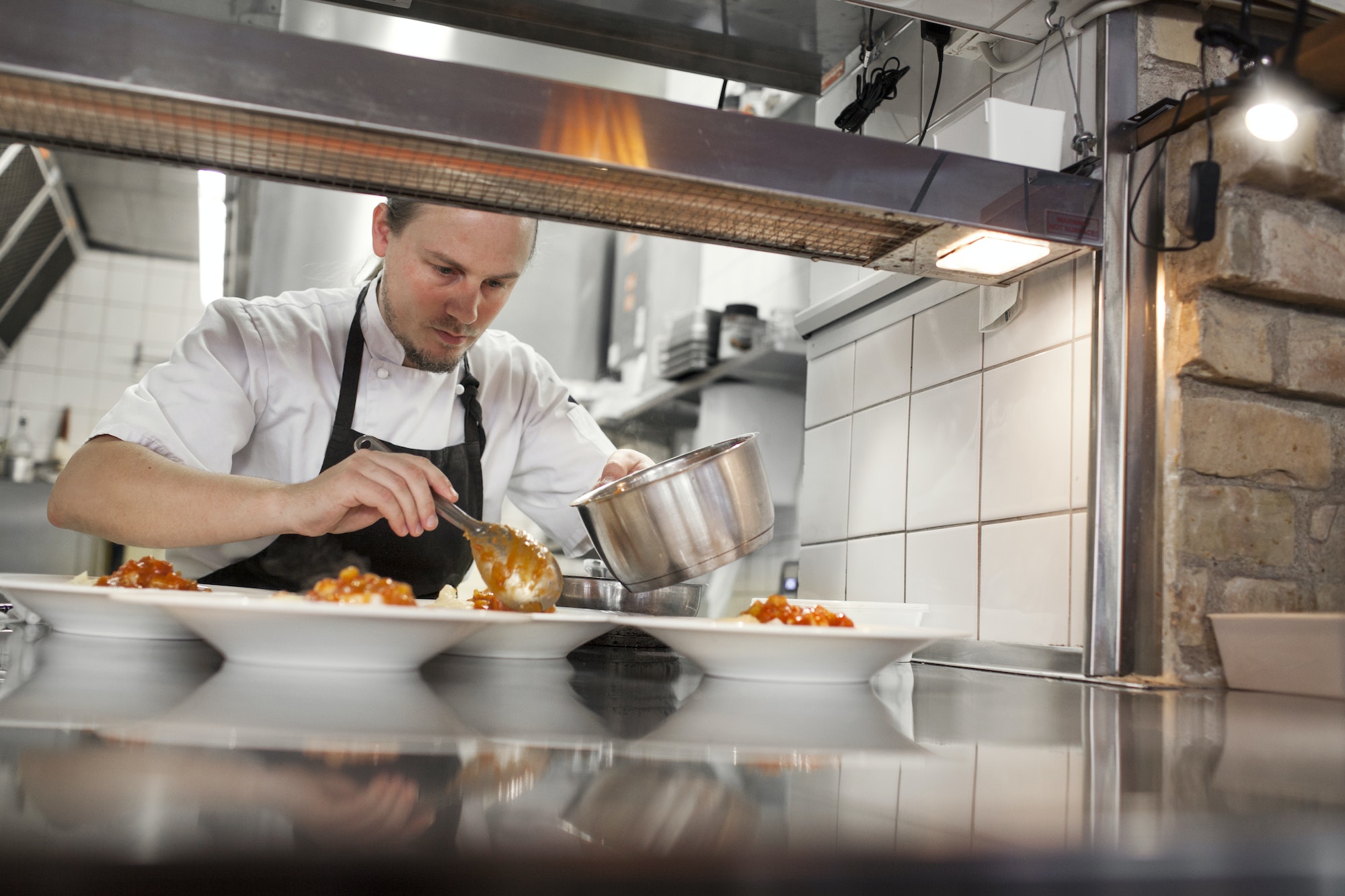 Chef serving food in plate at kitchen counter restaurant